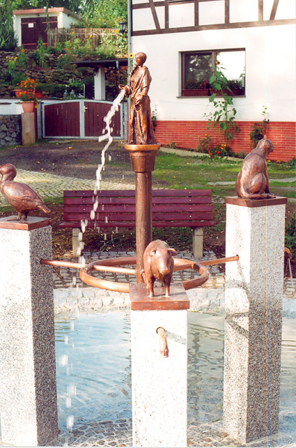 Dorfbrunnen Rodau, 4 Bronzefiguren, 3 Granitstelen 1,30 m hoch, 4 Wasserspeier, Durchmesser 6 m, 2010
